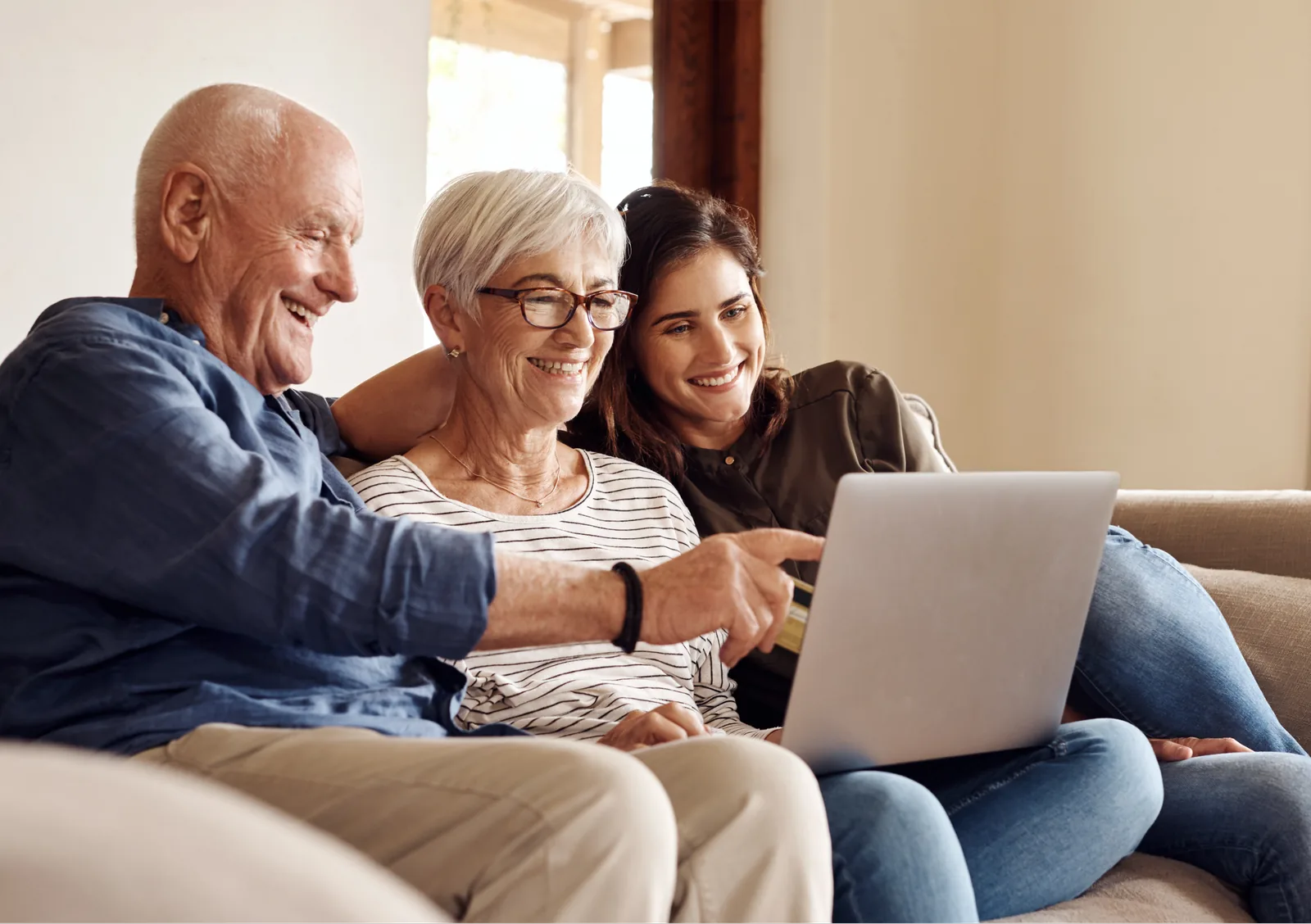 Famiglia che consulta il computer insieme, seduta sul divano
