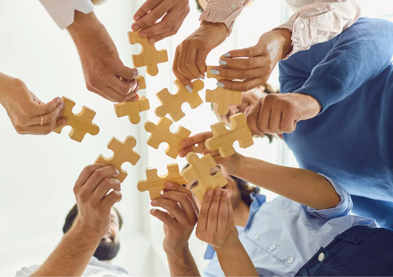 Mani che uniscono i pezzi di un puzzle: il lavoro di squadra